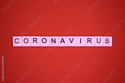 Coronavirus word wooden cubes on a red background. Novel coronavirus 2019-nCoV, MERS-Cov middle East respiratory syndrome.