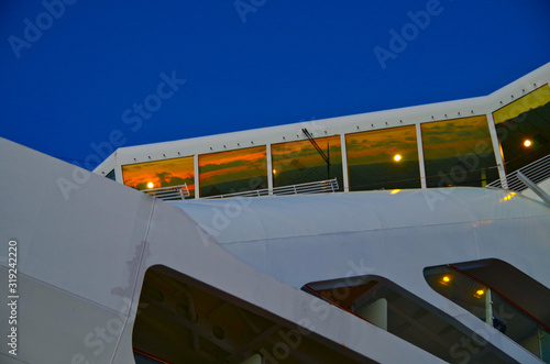 Navigational bridge, bow and superstructure detail view close up of modern cruiseship or cruise ship liner during sunset or dawn photo