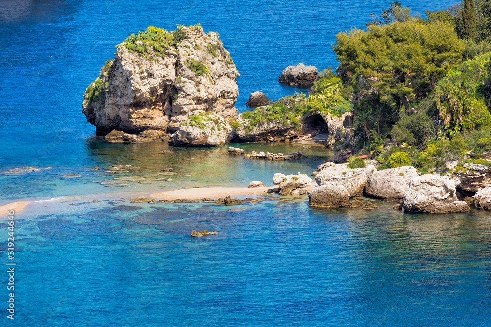 Big rock and narrow path connecting Isola Bella island to mainland Taormina beach, Sicily, Italy.