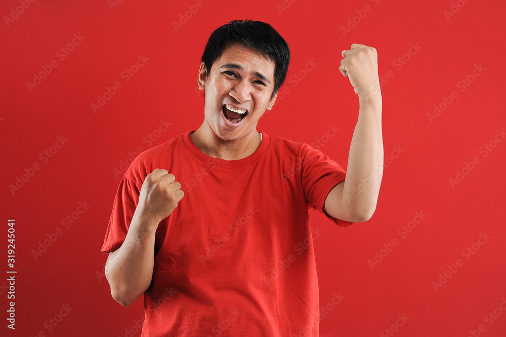 Young asian man happy and excited expressing winning gesture. Successful and celebrating Young asian man happy and excited expressing winning gesture. Successful and celebrating