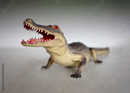 Figure of crocodile made of plastic close-up open mouth with terrible teeth. Children's games or collecting. Close up. Selective focus. © Zakharenkova