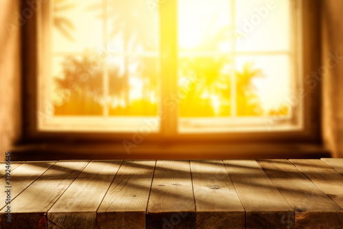 Wooden board of free space for your decoration and top cofer of shadows.Window space and blurred palms.