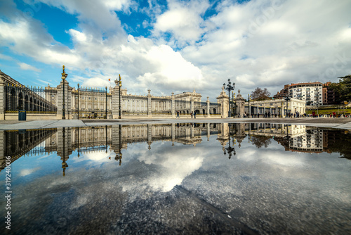 Royal Palace in Madrid under a cloudy sky reflected in the water