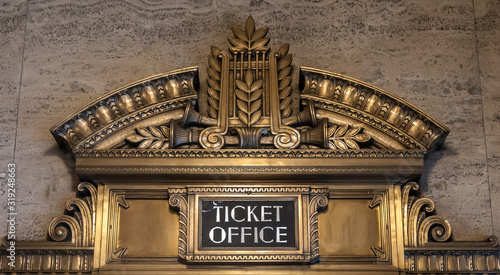 Ticket office ornate bronze sign against a brown marble wall in Chicago's Civic Opera House