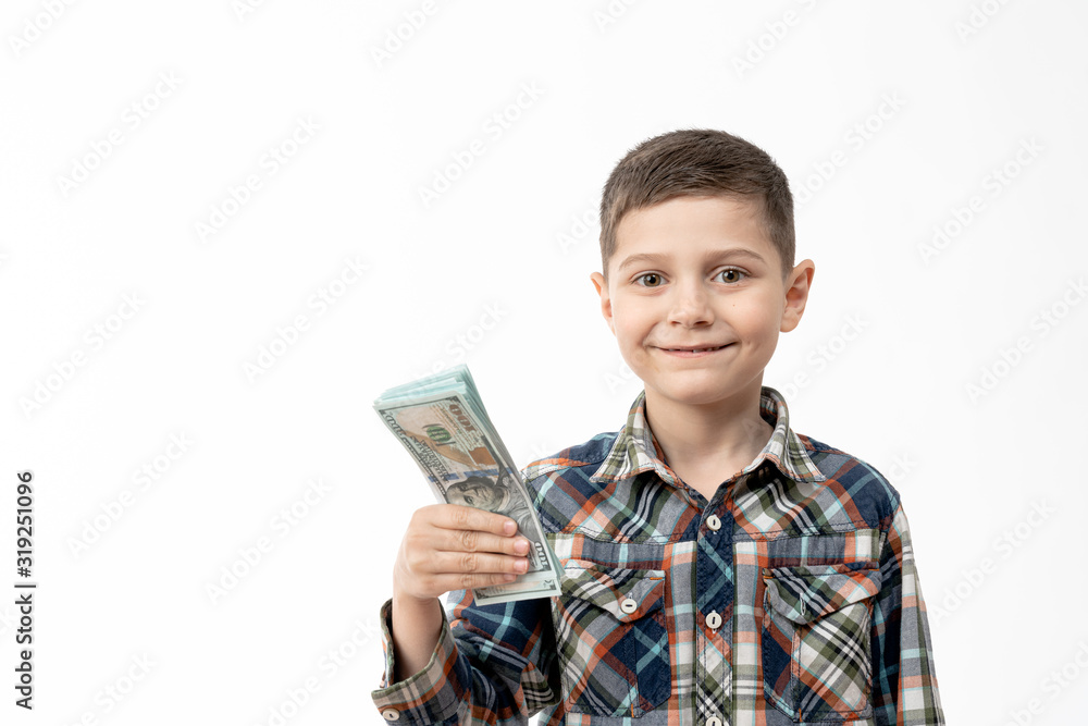 Happy smiling little boy in shirt holds banknotes in his hand and looking at the camera isolated over white background Happy smiling little boy in shirt holds banknotes in his hand and looking at the camera isolated over white background