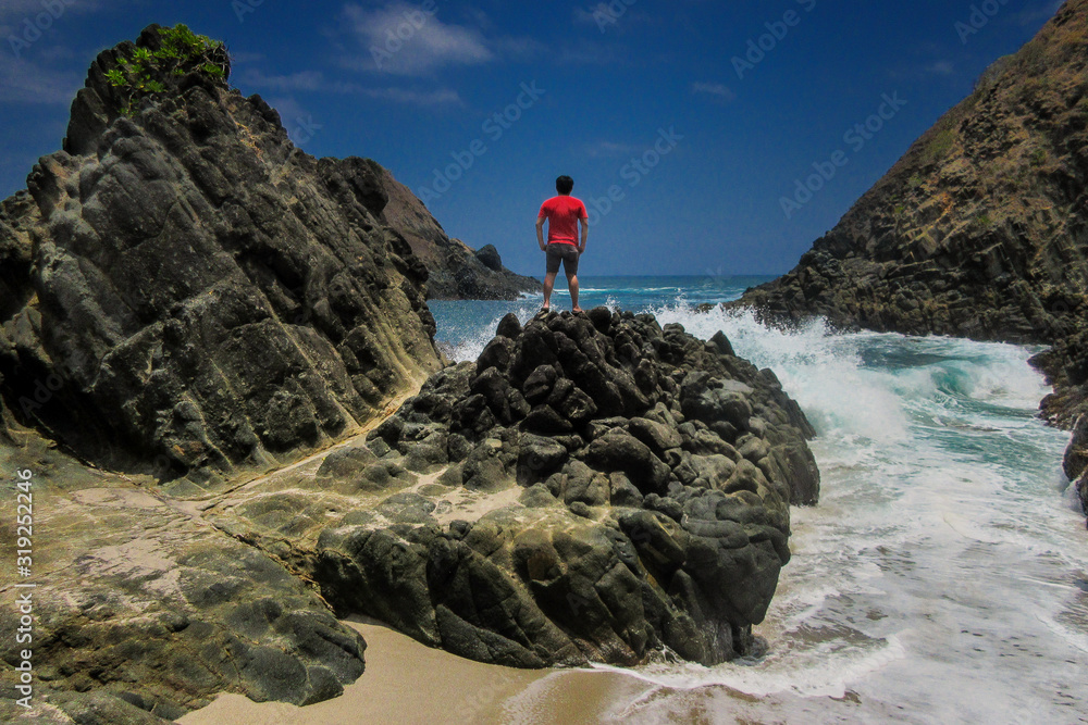 Man Standing At Rock Beach