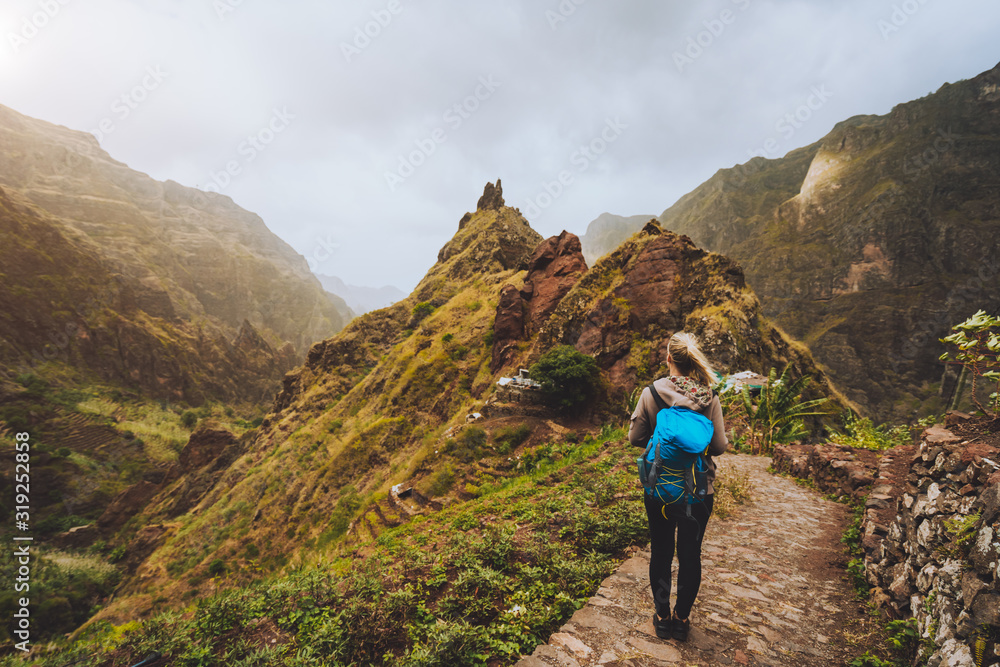 Santo Antao Island Cape Verde. Tourist girl with backpack walking down along the trekking route to verdant Xo-Xo valley between mountain peaks