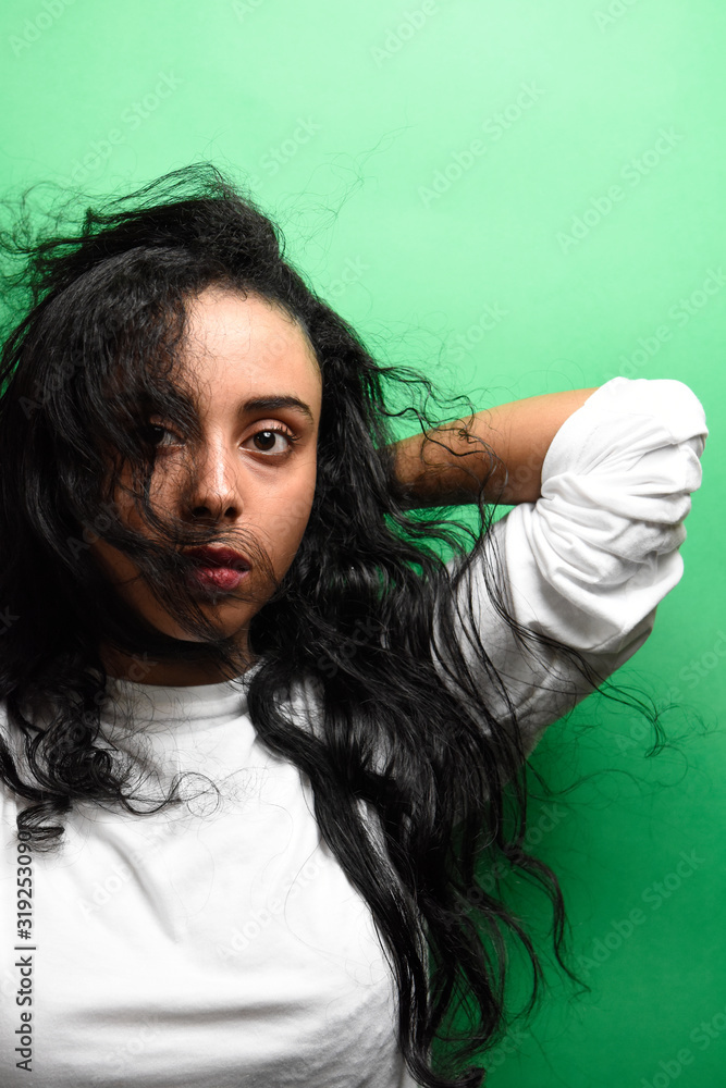 Spectacular middle eastern young woman with her black hair. Indoor photo of wonderful female model on green background. Spectacular middle eastern young woman with her black hair. Indoor photo of wonderful female model on green background.