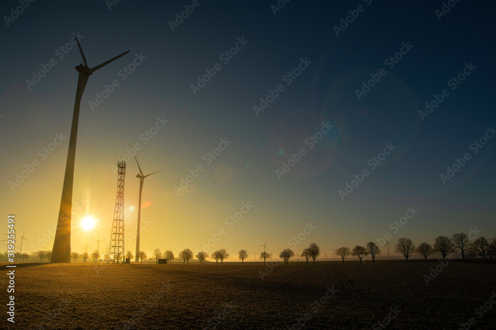 Wind turbines at sunset on a meadow, concept of ecological energy, climate change, renewable energy