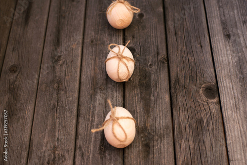 Happy Easter! Wooden eggs on a wooden background. Minimal easter concept. Easter card with copy space for text. Top view, flatlay.