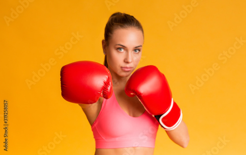 Young Sporty Woman Wearing Red Boxing Gloves, Ready To Attack © Prostock-studio