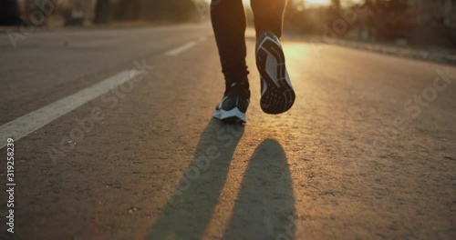 The legs are taken in close-up. Morning run. The glare of the sun. Cold weather. 4k 