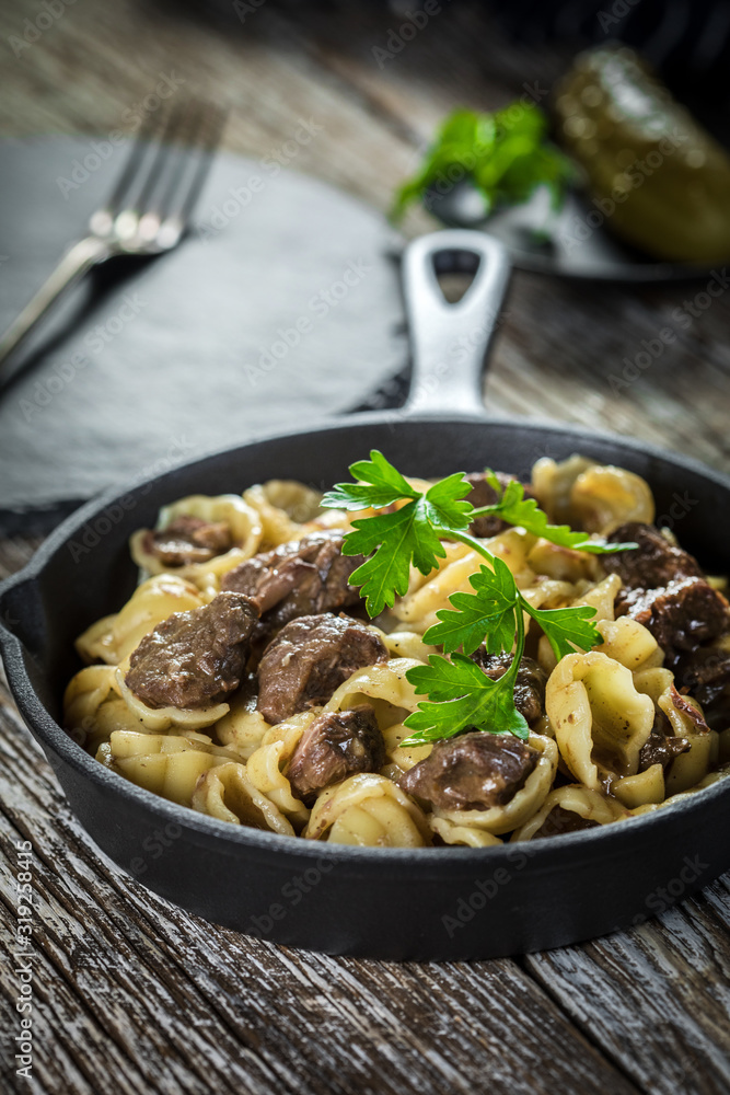Italian pasta shells with beef sauce in cast iron pan.