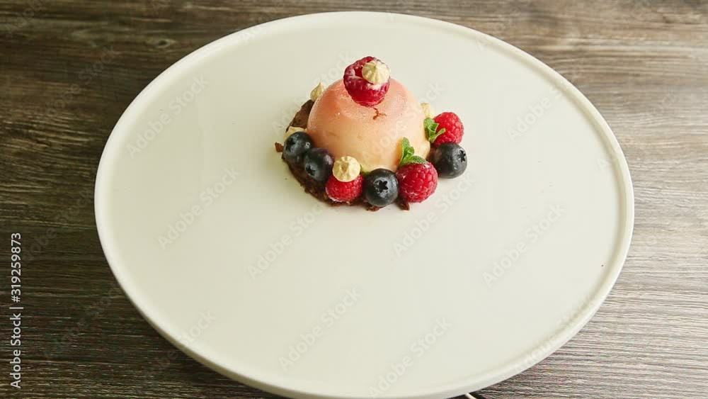 zoom in at icing dessert trendy decorated with berries rotates on plate zoom in at icing dessert trendy decorated with berries rotates on plate