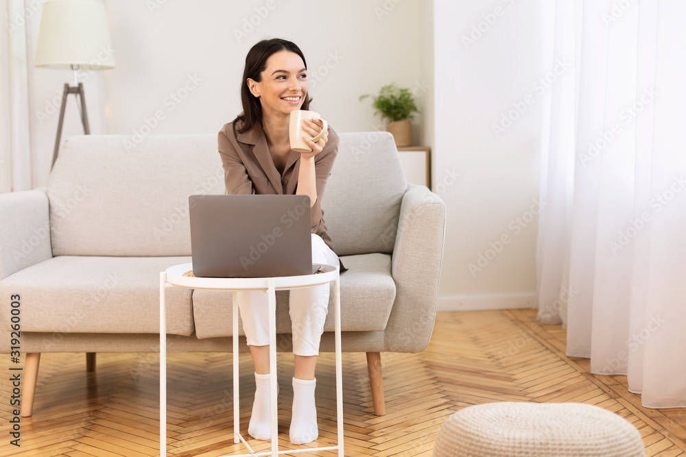 Young woman drinking coffee sitting on the couch Young woman drinking coffee sitting on the couch