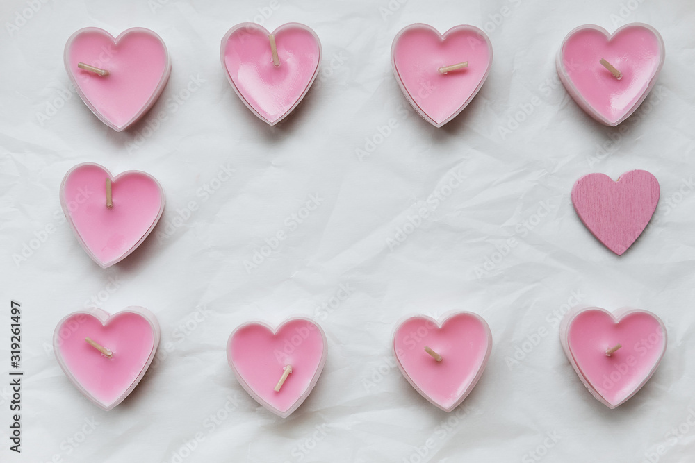 Scented pink candles in the form of hearts, and in the middle there is an empty background for text. Photo taken by flat lay.