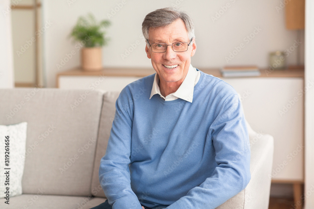 Smiling Senior Gentleman Sitting On Couch At Home Smiling Senior Gentleman Sitting On Couch At Home