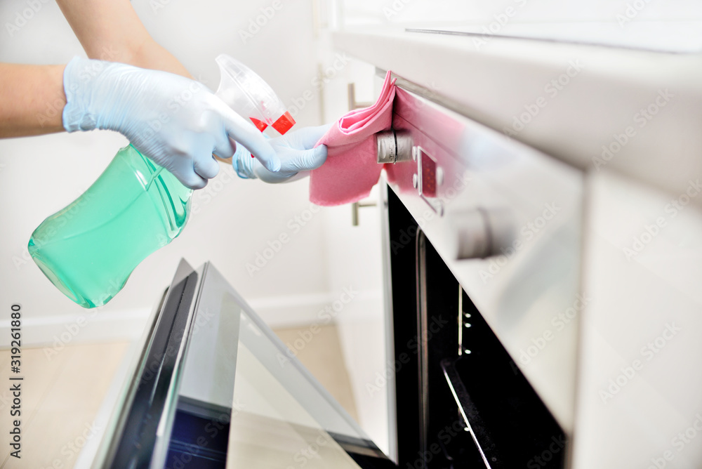 Woman in gloves cleaning kitchen.	 - obrazy, fototapety, plakaty 