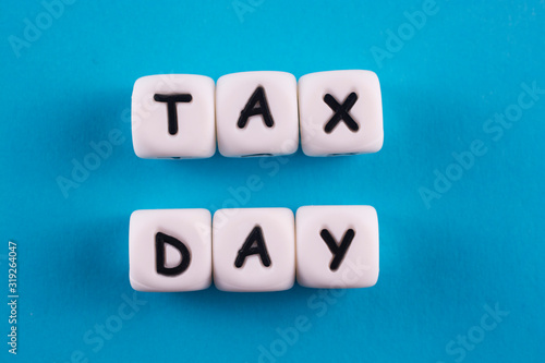Tax concept. White plastic blocks with letters TAX DAY on a blue background.