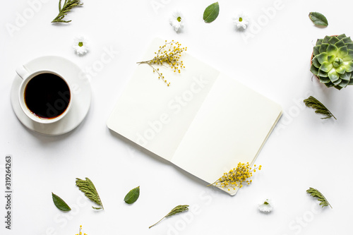 Notebook with cup of coffee on white background top view mockup