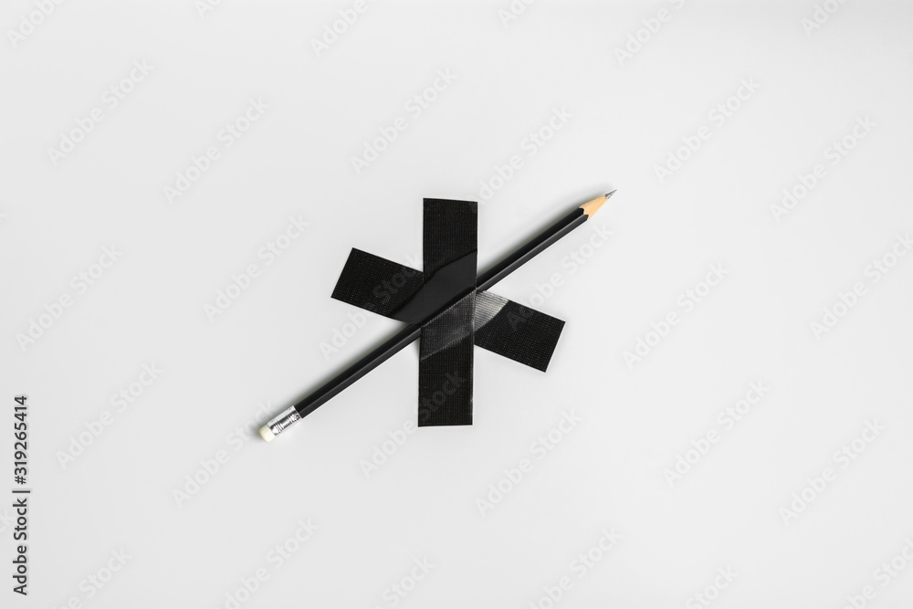 black pencil pinned with black cloth tape.