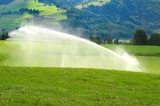 water sprinklers inaffiano cultivated fields in Val Pusteria. South Tyrol in Italy.