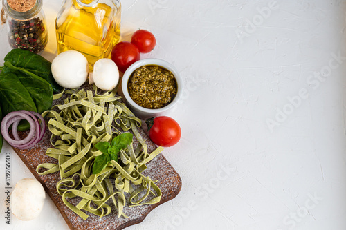 Pasta, vegetables, herbs and spices, olive oil, ingredients for Italian cuisine against white background.