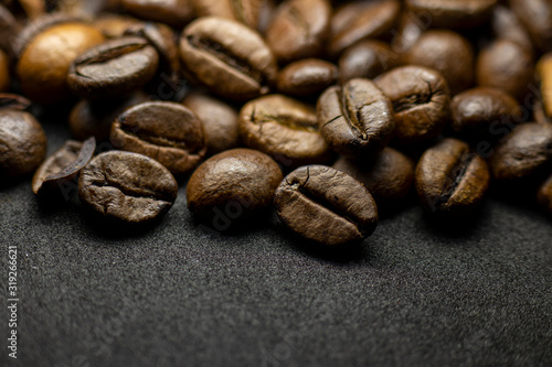 Fototapeta Naklejka Na Ścianę i Meble -  Coffee in beans on dark background. Abstract background texture.Coffee beans texture. Food background of coffee beans