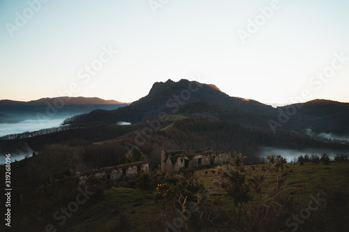 Ruins of an old castle and an iconic mountain of Basque Country during sunset