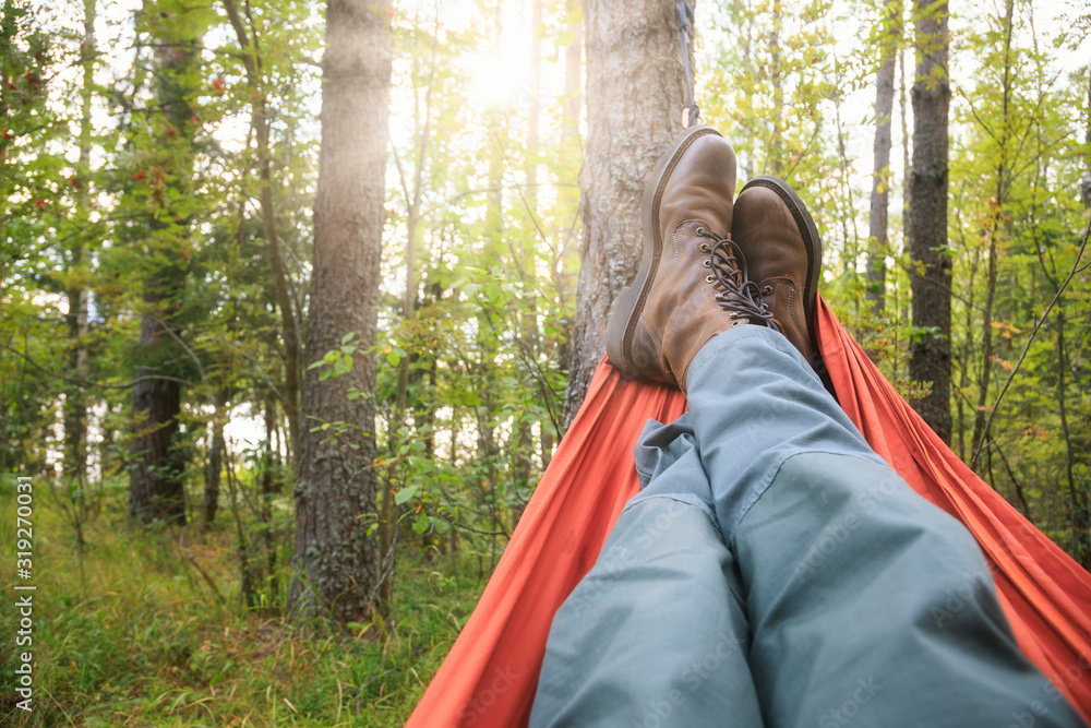 Man relaxing in camping hammock - obrazy, fototapety, plakaty 