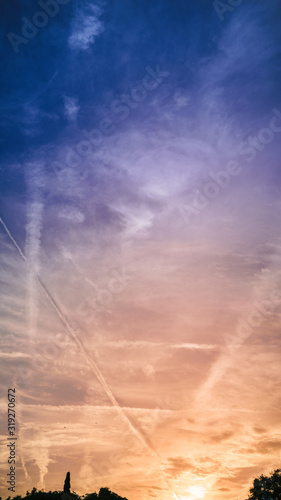 Plane condensation trails on sunset sky of Barcelona city  Spain 