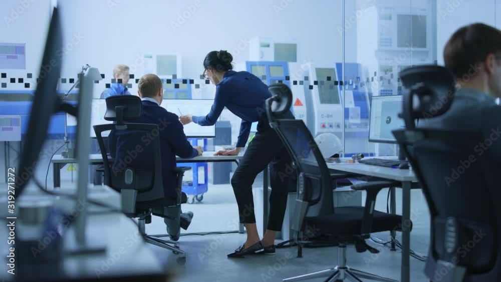 Modern Factory: Female Project Supervisor Talks to a Male Industrial Engineer who Works on Computer. They use CAD Software for Design, Development. High-Tech Industrial Facility. Slow Motion Modern Factory: Female Project Supervisor Talks to a Male Industrial Engineer who Works on Computer. They use CAD Software for Design, Development. High-Tech Industrial Facility. Slow Motion