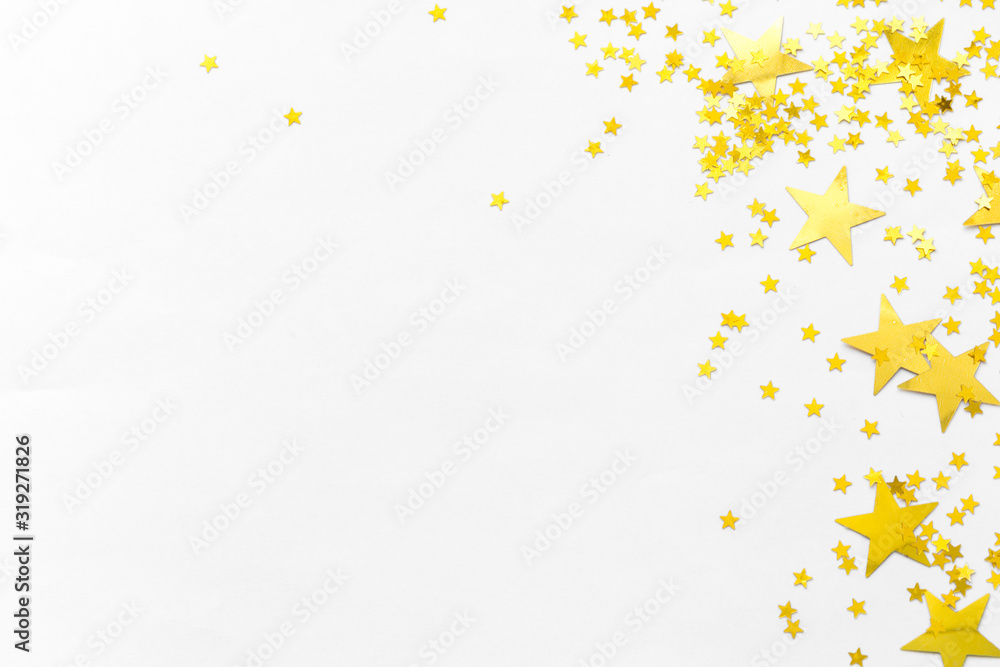 Gold confetti and stars and sparkles on a light background. Top view, flat lay. Copy text. Bright and festive background. For Christmas, New Year, Mother's Day.