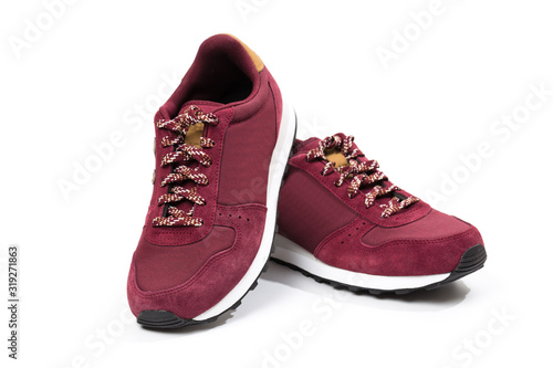 a pair of new burgundy  cherry sneakers or athletic shoes isolated on a white background.