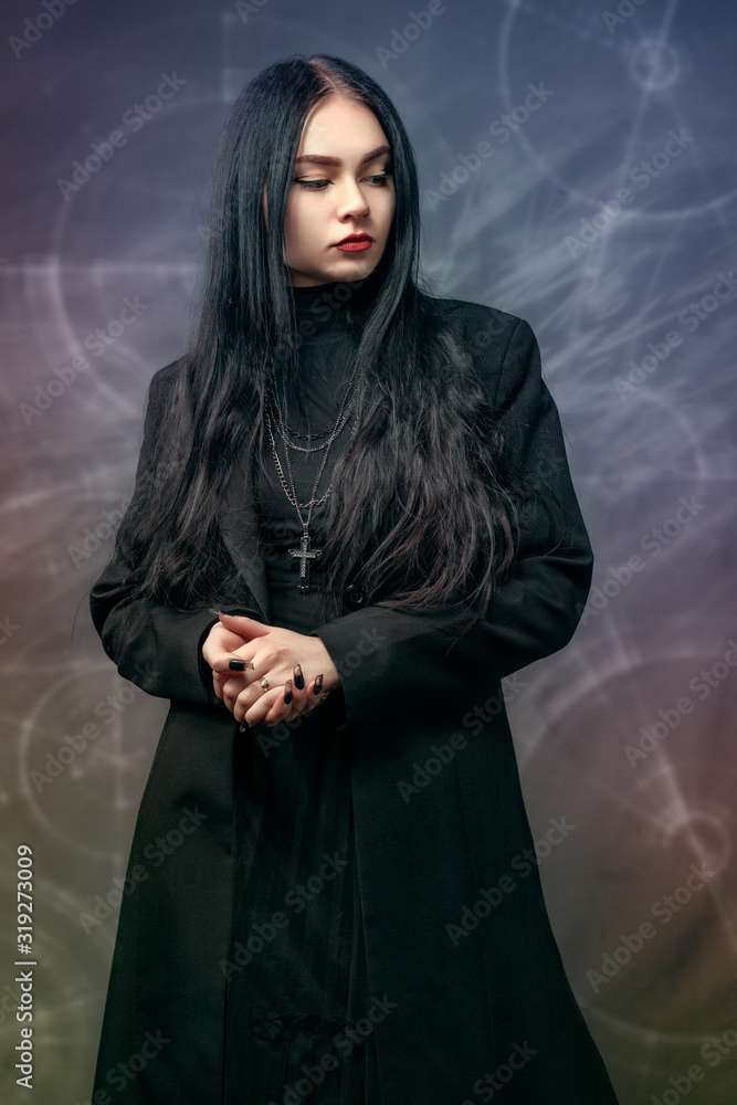 Young girl with black hair in clothes, black classic style. With Gothic elements Young girl with black hair in clothes, black classic style. With Gothic elements