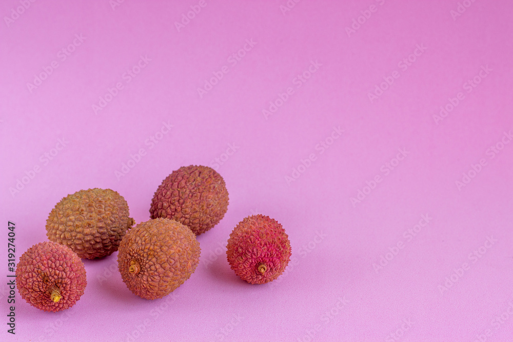 Tropical lychee fruit on a pink background.Selective focus. Tropical lychee fruit on a pink background.Selective focus.