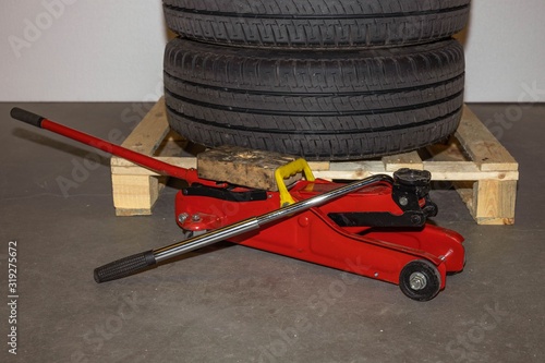 Close up car tyres on wheels storage  on a pallet and tire replacement jack. Car repair box. Transport backgrounds. photo