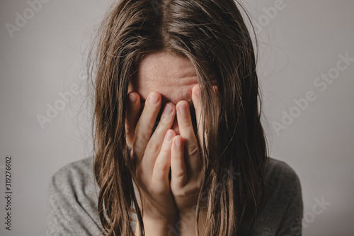 Woman covers face in hands. Concept of despair, depression, loss or mental condition photo