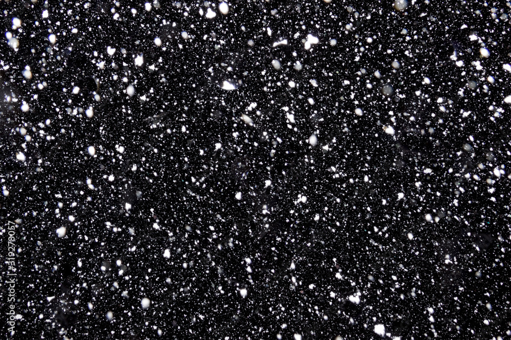 Real falling snow on a black background for use as a texture layer in a photo design. Flying snowflakes illuminated by a lantern on the background of the night sky Real falling snow on a black background for use as a texture layer in a photo design. Flying snowflakes illuminated by a lantern on the background of the night sky