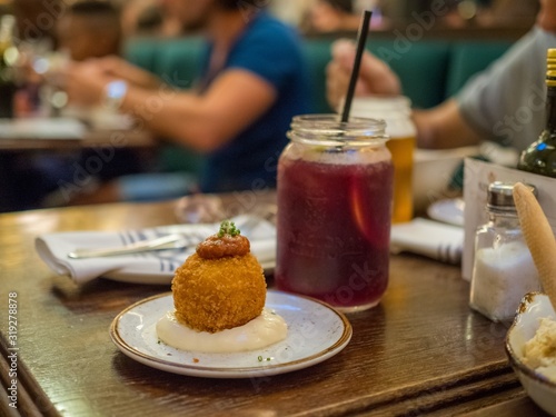 Photography Closeup shot of a Spanish tapa called bomba served at a restaurant in Barcelona,