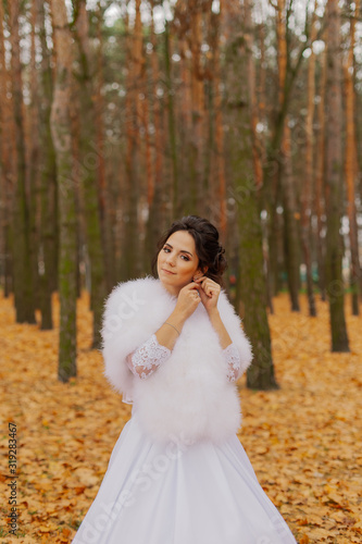Happy beautiful bride in the autumn in the forest.