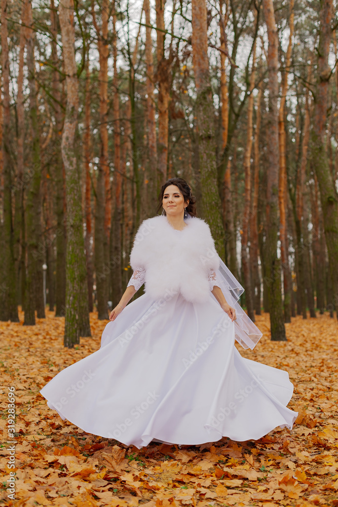 Happy beautiful bride in the autumn in the forest.