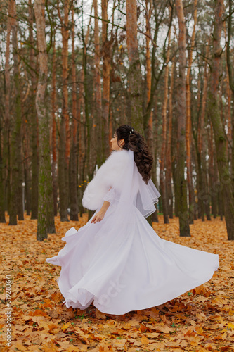 Happy beautiful bride in the autumn in the forest.