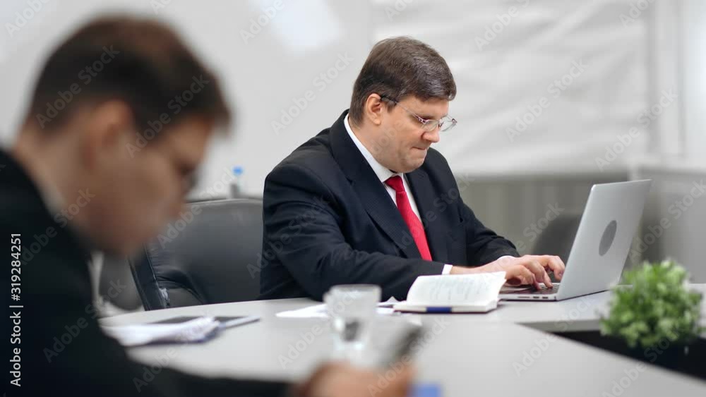 Focused male office worker in suit working using laptop typing on keyboard Focused male office worker in suit working using laptop typing on keyboard