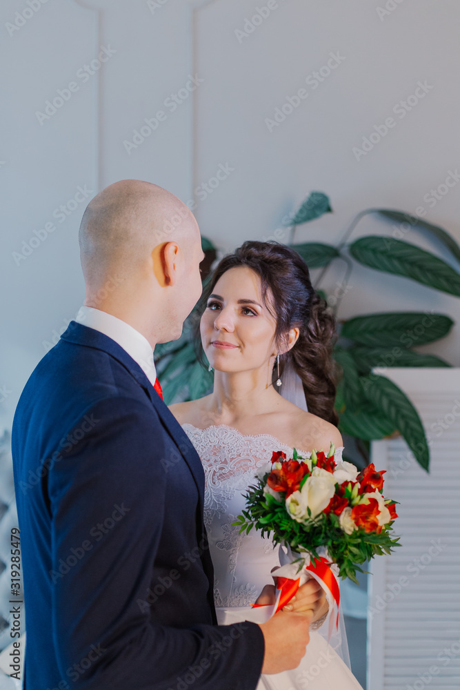 Happy bride and groom in a room hug each other. Happy bride and groom in a room hug each other.