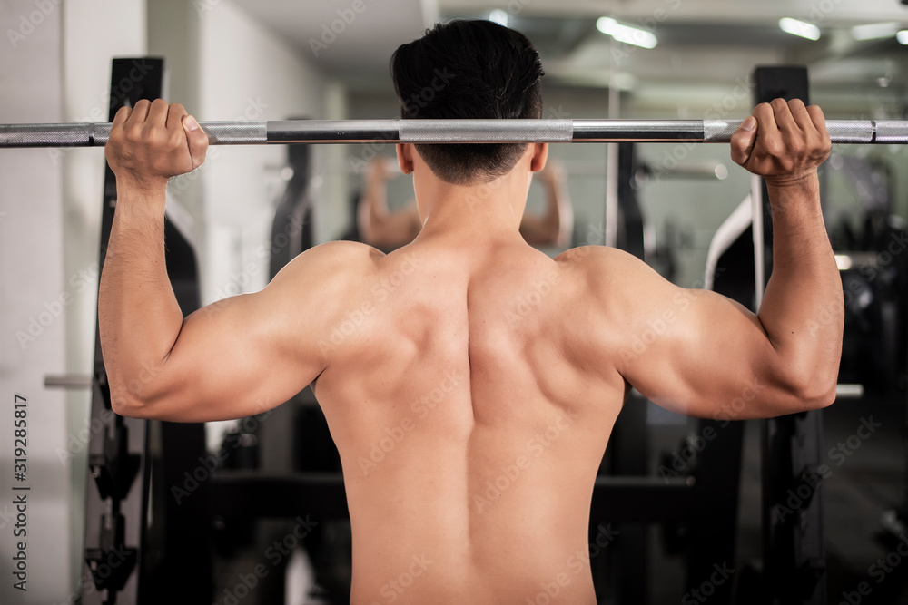 Bodybuilder man with big muscular back in the gym Bodybuilder man with big muscular back in the gym