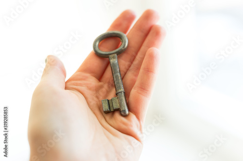 Old key in womans hand, The concept of buying a new home or sold house