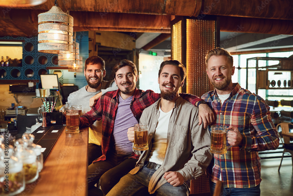 Group of male friends drink beer at a party in a bar.