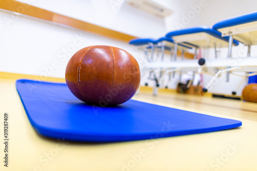 Gym ball lies on a blue sport mat