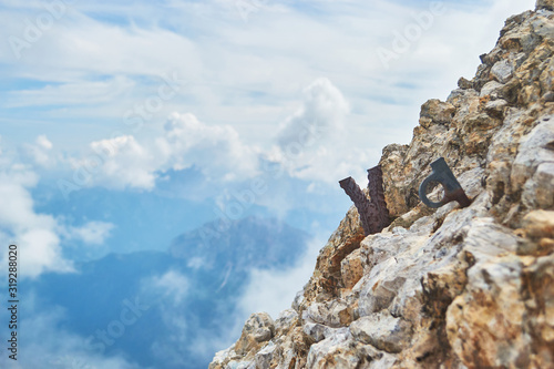 Remains of a steel rock anchor and an old climbing piton on via ferrata Eterna route, in Dolomites mountains, Italy.